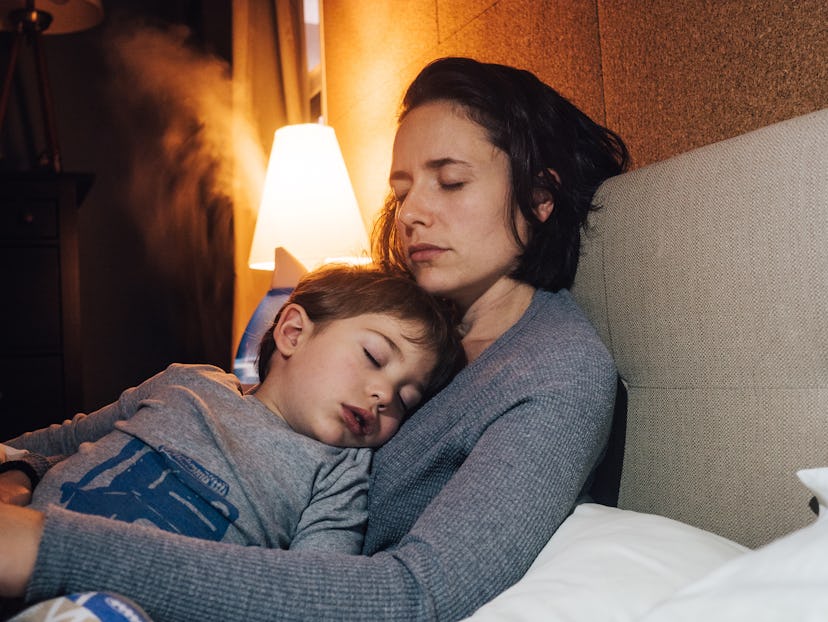 a kid with a cold snuggling with his mom in an article about why is your baby coughing at night.