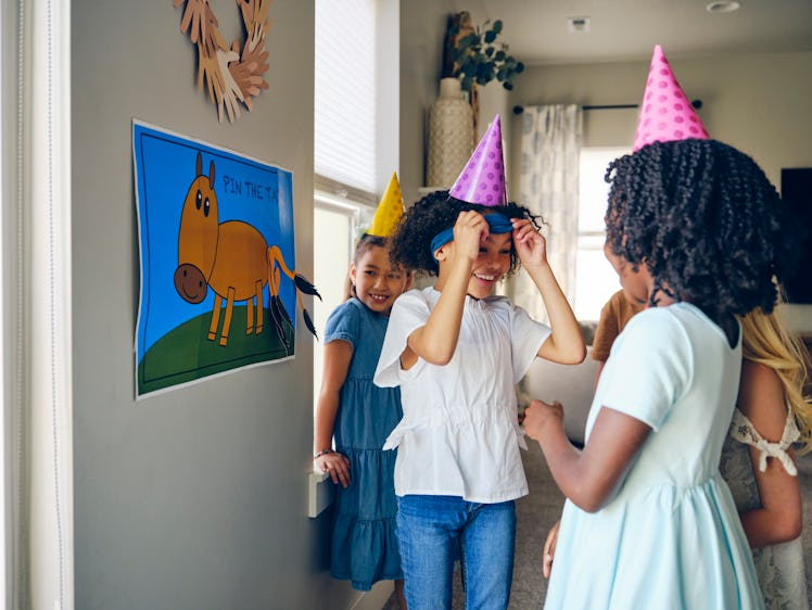 A group of children celebrating a birthday with a party in a home.