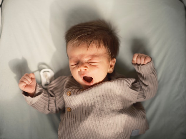 very little baby yawning in morning light in a round up of literary boy names 