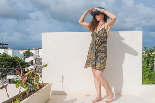 This is a portrait of a 40 year old woman wearing a sundress and a hat on a sunny, summer day in Tul...