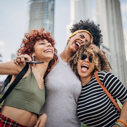 Three women laughing during the 2022 fall equinox, which will affect their zodiac signs most.