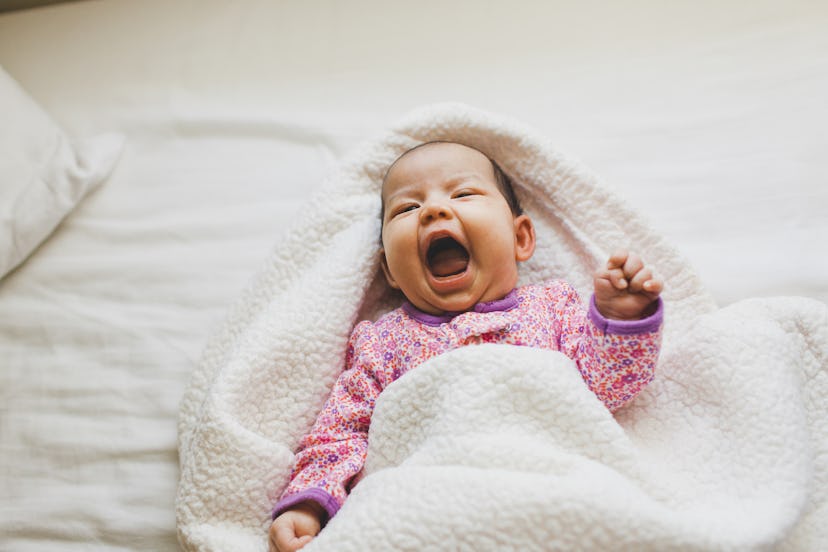 a cute baby in a blanket in a round up of girl names that start with "T"