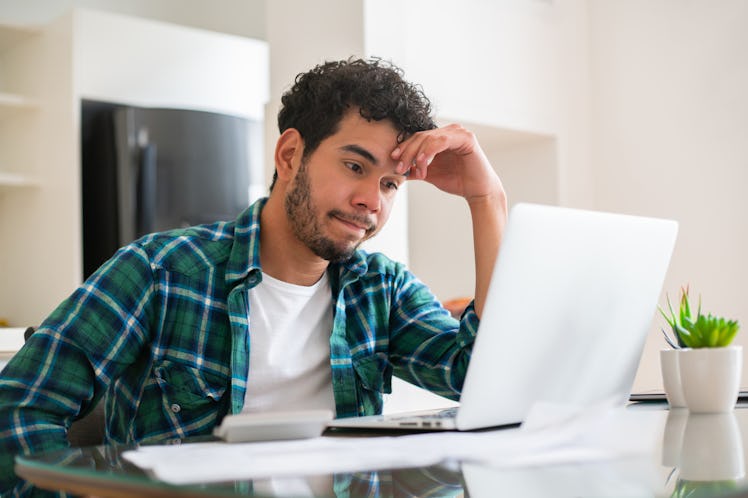 A man on his computer looks frustrated