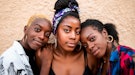 Three women lean their heads together during the 2022 fall equinox, which will affect their zodiac s...