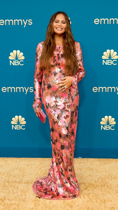 Chrissy Teigen cradling her baby bump at the 2022 Emmys