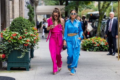 Guests wearing pink and blue pants, outside Coach at New York Fashion Week.