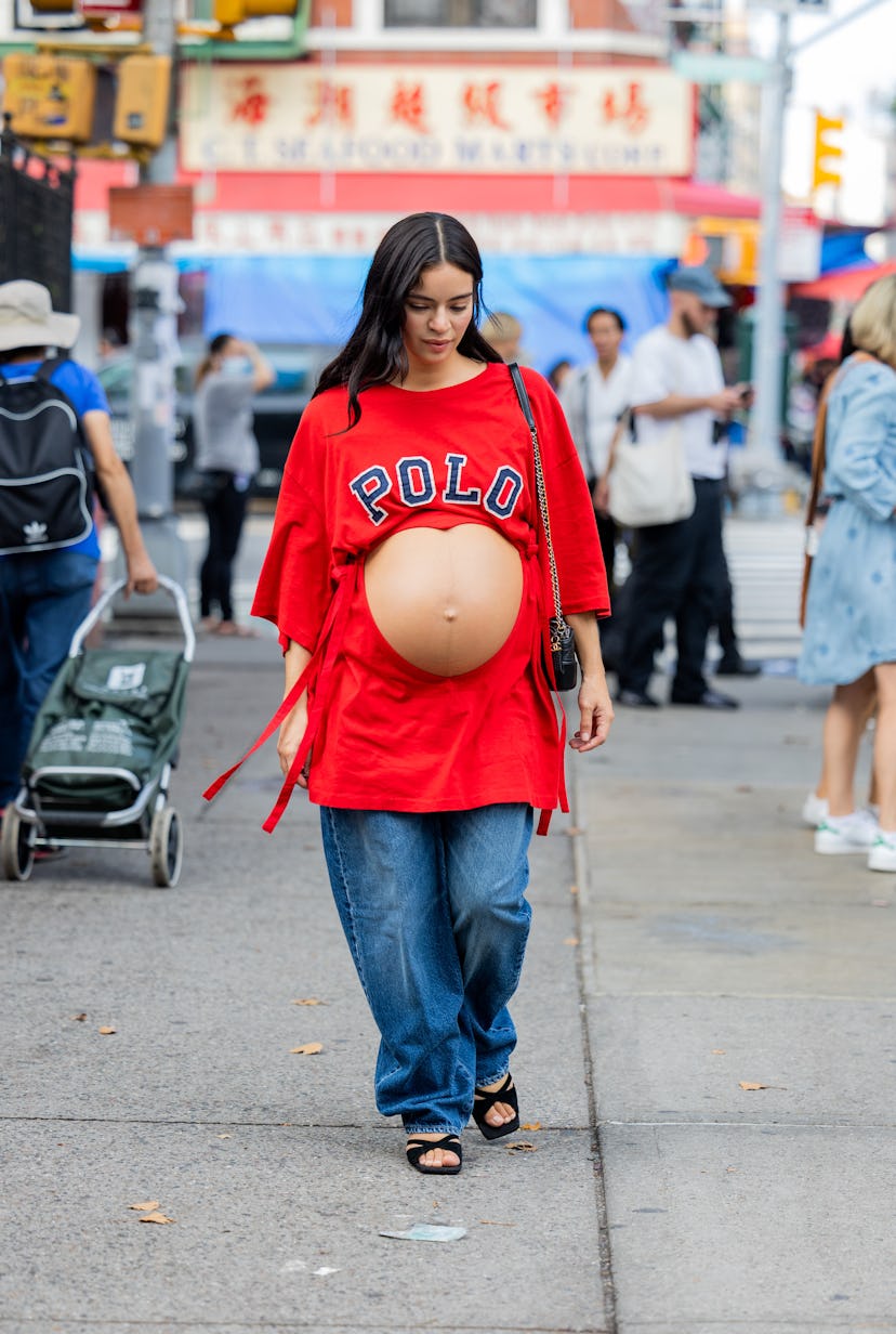  pregnant guest wearing cut out red shirt, denim jeans outside Maryam Nassir Zadeh.