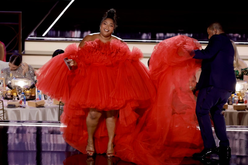 Lizzo and host Kenan Thompson speak onstage at the 2022 Emmy Awards.