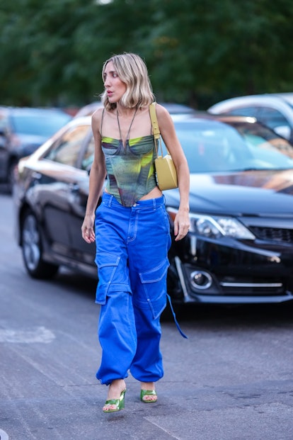 A guest wears a corset and blue, baggy cargo pants during New York Fashion Week.