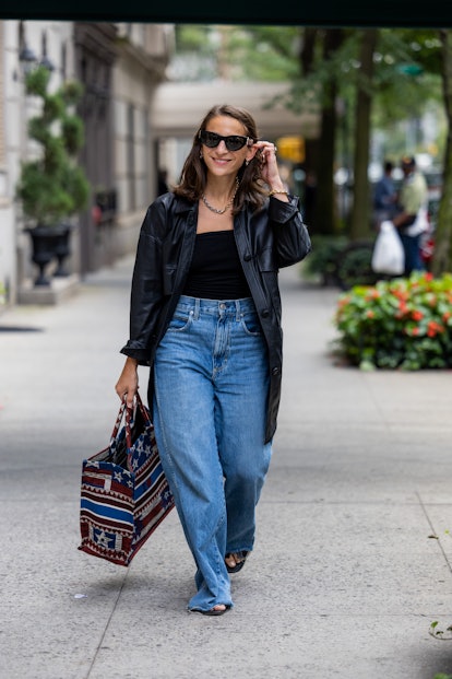 A guest in a leather jacket and baggy jeans at New York Fashion Week 