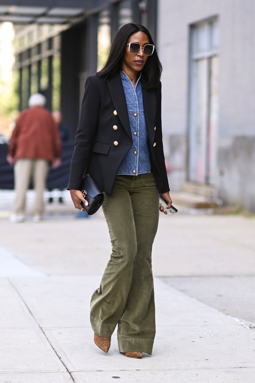  A guest is seen wearing a blue blazer, jean top and green pants outside the Veronica Beard show dur...