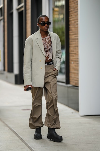 A guest during New York Fashion Week wearing a tan blazer and oversized pants.