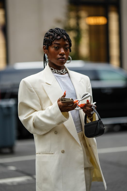 NEW YORK, NEW YORK - SEPTEMBER 12: A guest wears silver and blue rhinestones large earrings, silver ...