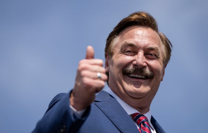 Mike Lindel in a suit smiling and showing thumbs up