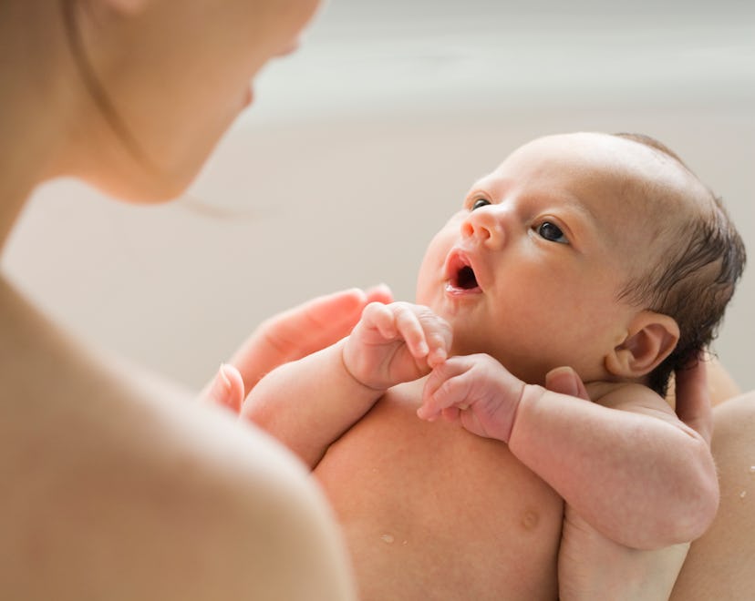 a newborn baby in moms arms in an article about baby dry coughs