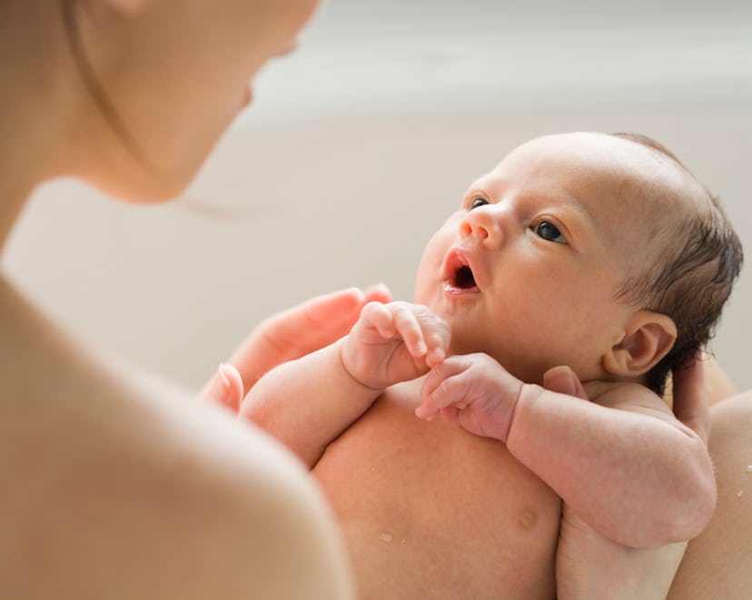 a newborn baby in moms arms in an article about baby dry coughs 