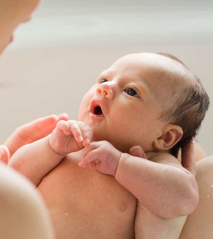 a newborn baby in moms arms in an article about baby dry coughs 