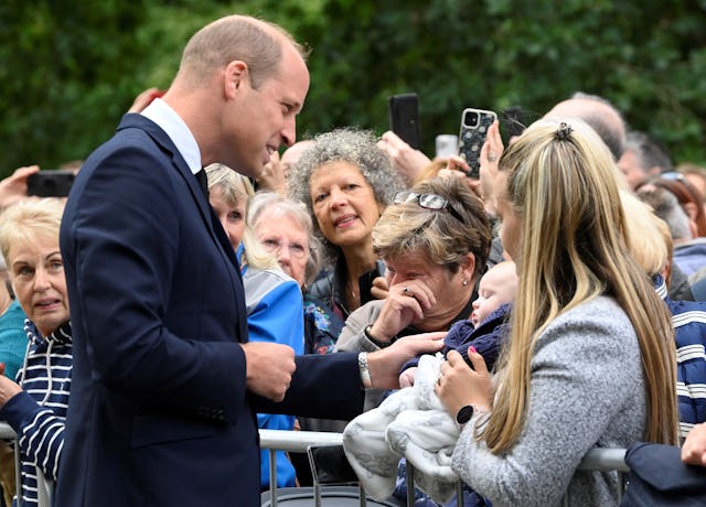 Prince Williams finds solace in the pets waiting outside Buckingham Palace.