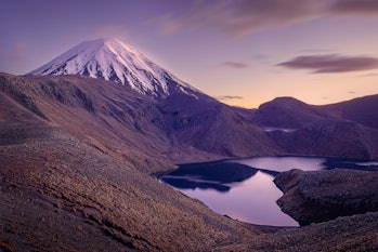 The glowing conical peak of Mount Ngauruhoe in the early morning with the Upper Tama Lake in the for...