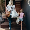 Real life young Australian mum and daughter bring in their groceries in eco shopping bags and basket