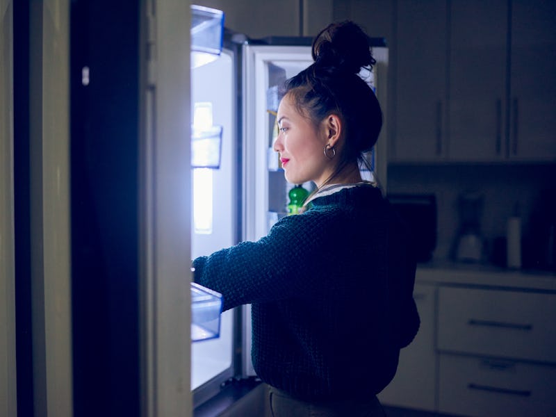 Cropped shot of an attractive young woman looking in her fridge for a midnight snack at home