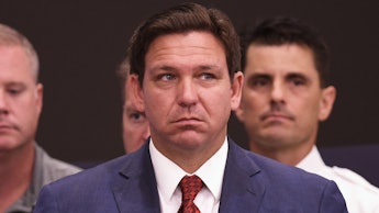 Ron DeSantis in a suit looking worried.