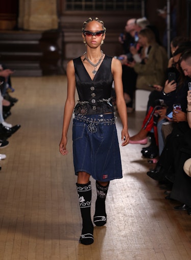 A model walking the runway in a black top and denim skirt at the Chopova Lowena show during London F...