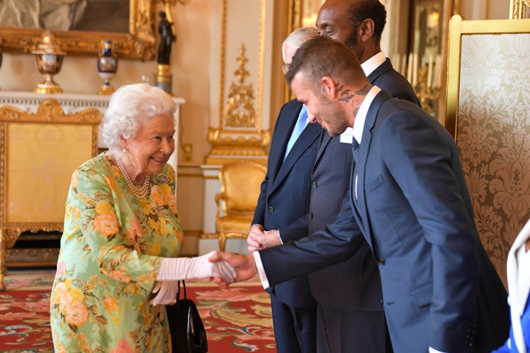 Britain's Queen Elizabeth II (L) greets former England international David Beckham