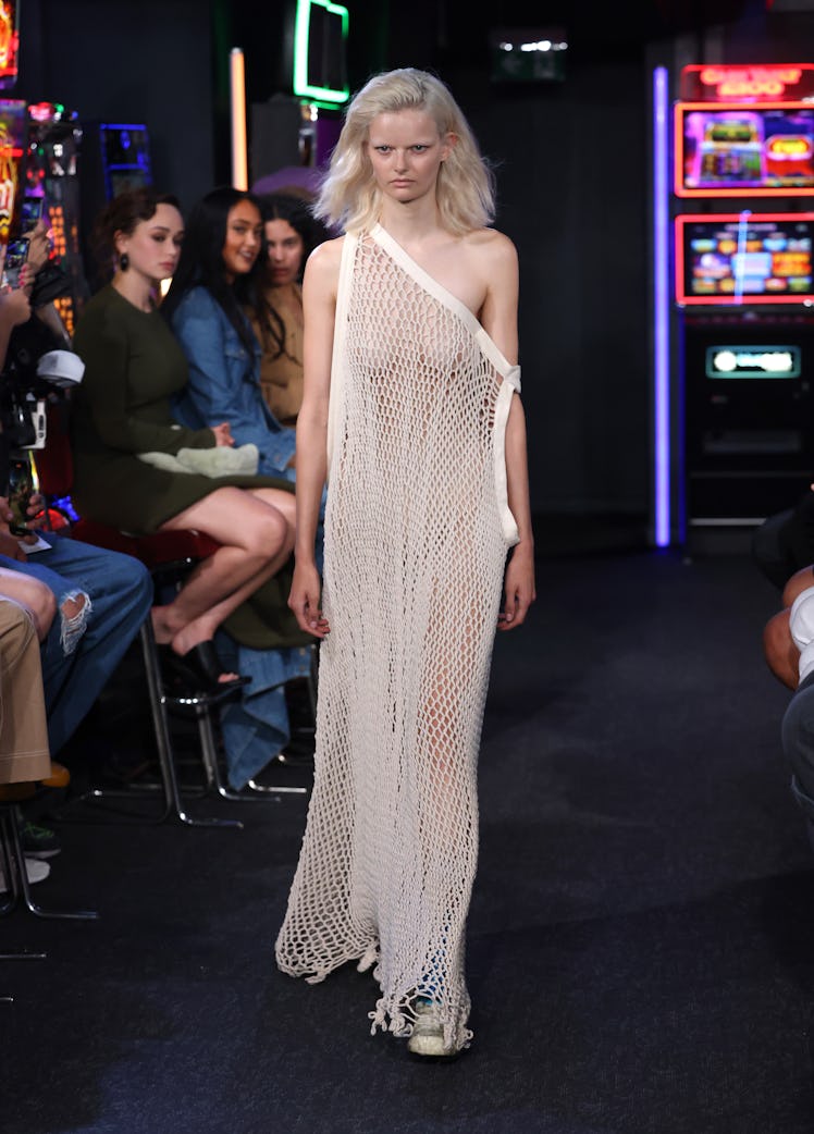 A model walking the runway in a white netted dress at the JW Anderson show during London Fashion Wee...