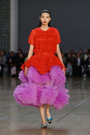 A model walking in a red and purple gown at the runway during the Molly Goddard show during the Lond...