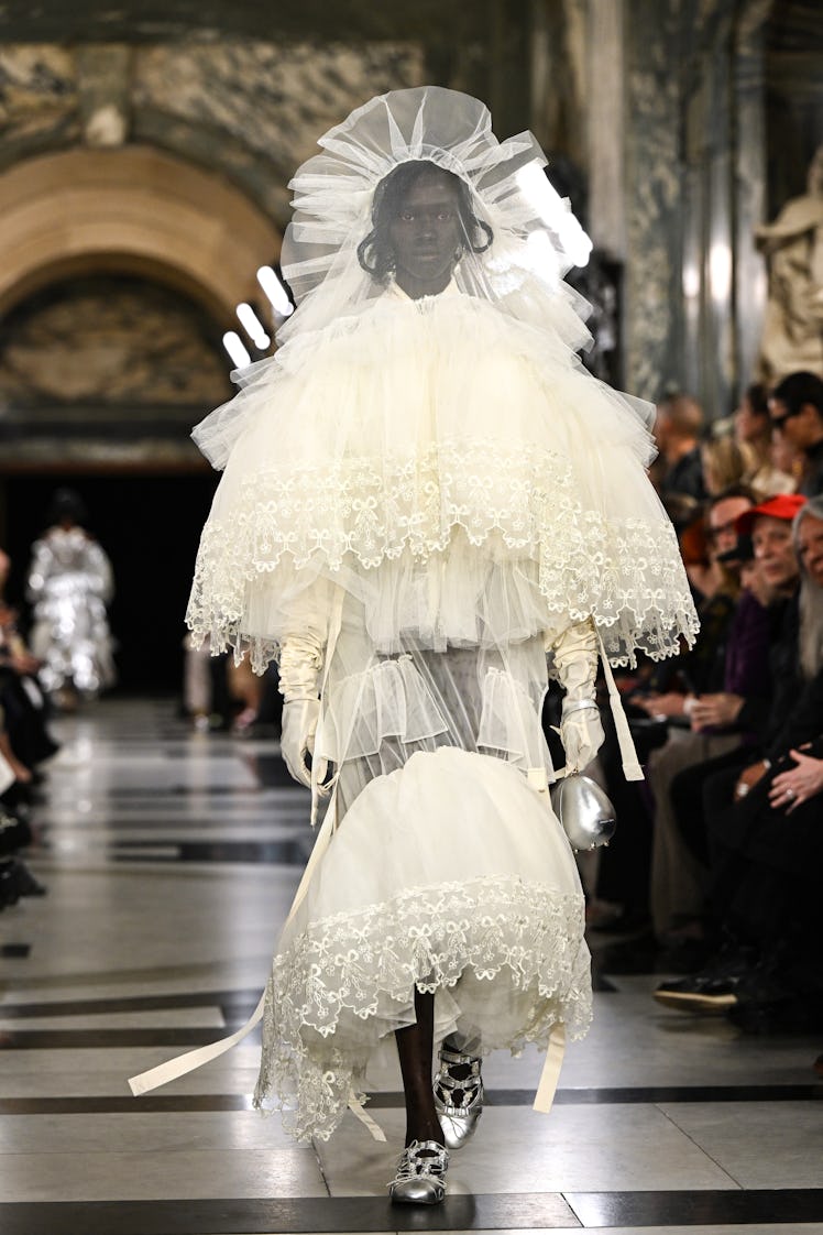 A model walking the runway in a white gown during the Simone Rocha show during London Fashion Week 
