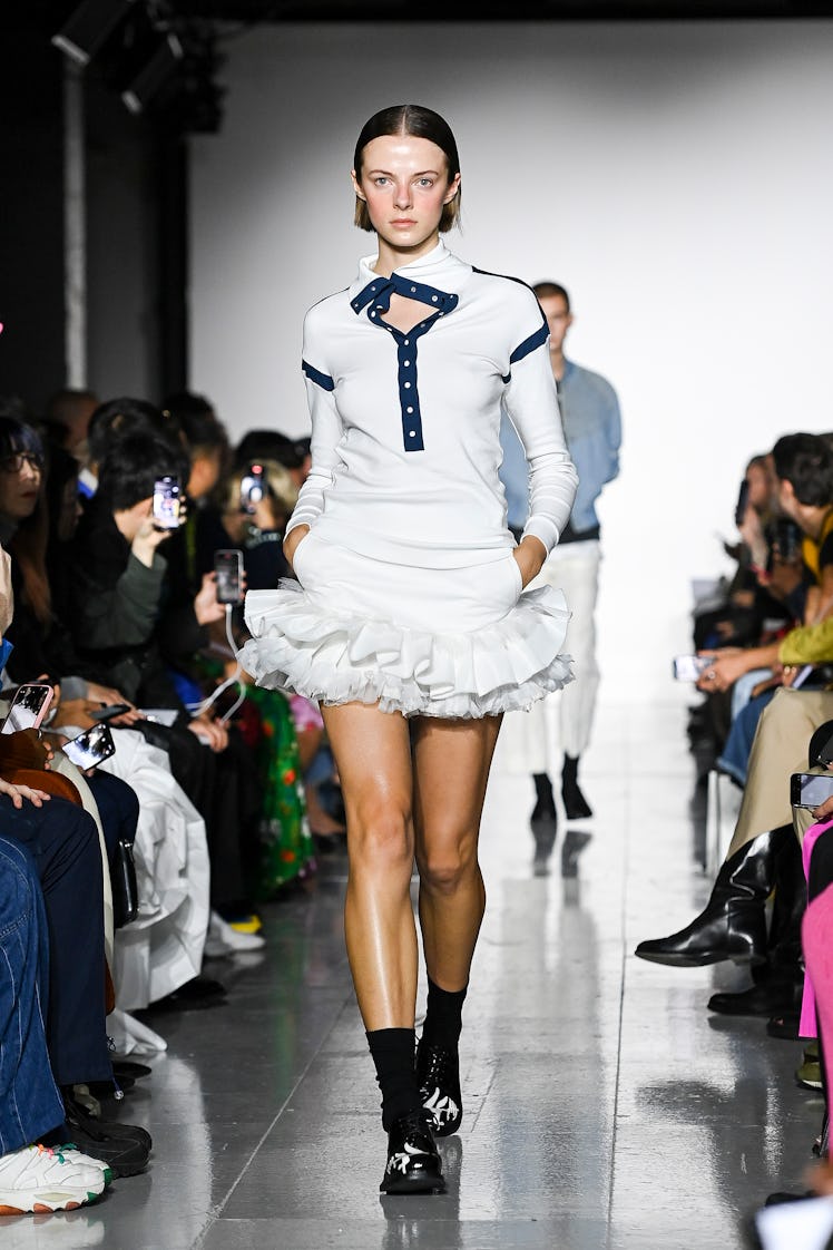 A model walking the runway in a white mini dress during the Stefan Cooke show 