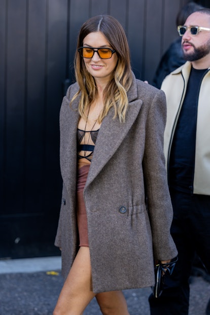 Camille Charriere wears grey coat, dress outside Nensi Dojaka during London Fashion Week.