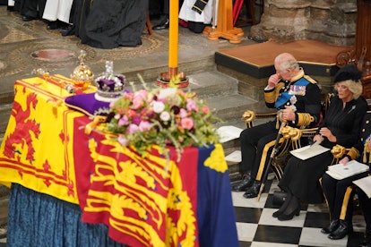 Britain's King Charles III (2nd R) and  Britain's Camilla, Queen Consort (R) sit in front of the cof...