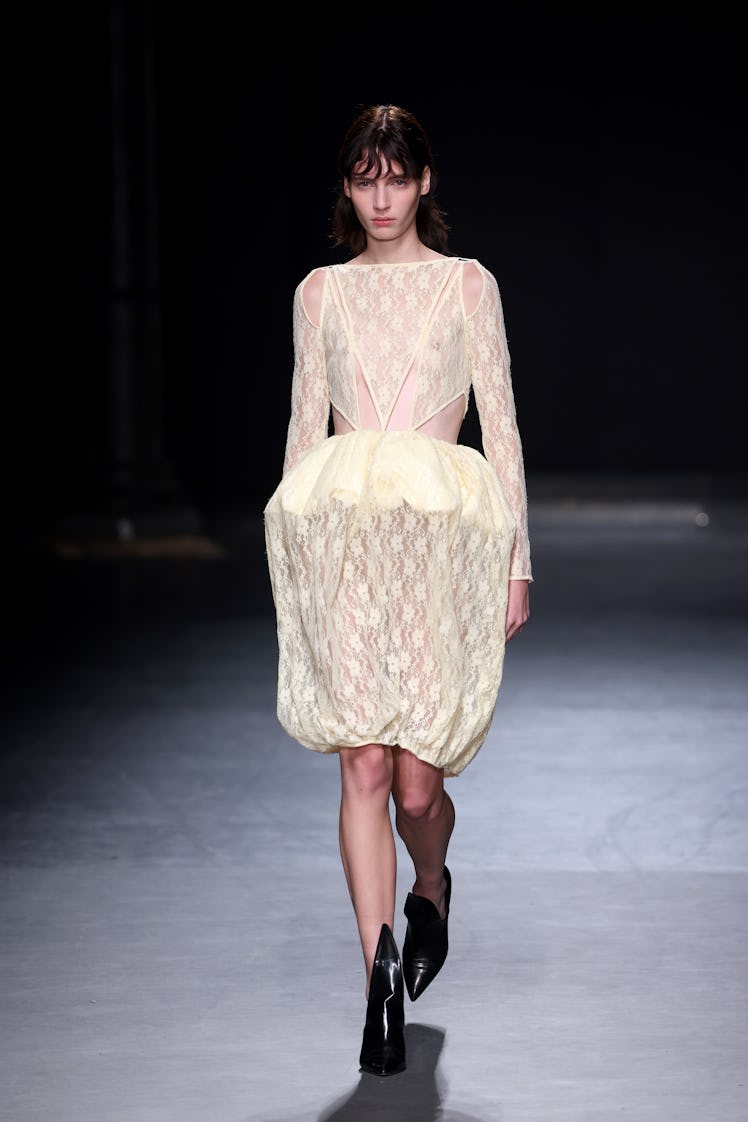 A model walking the runway in a white dress at the Christopher Kane show during London Fashion Week 