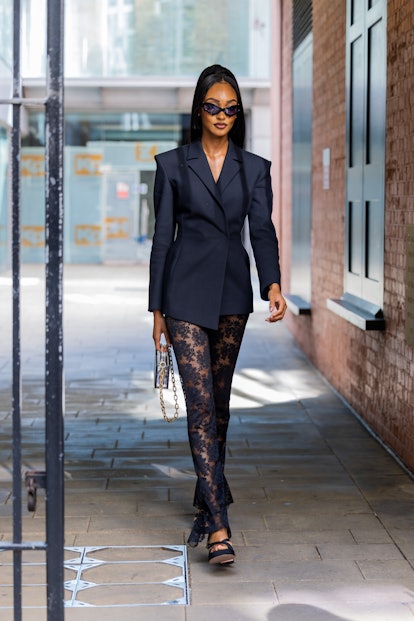  Jourdan Dunn wears black laced pants, navy blazer, bag outside Fashion East during London Fashion W...