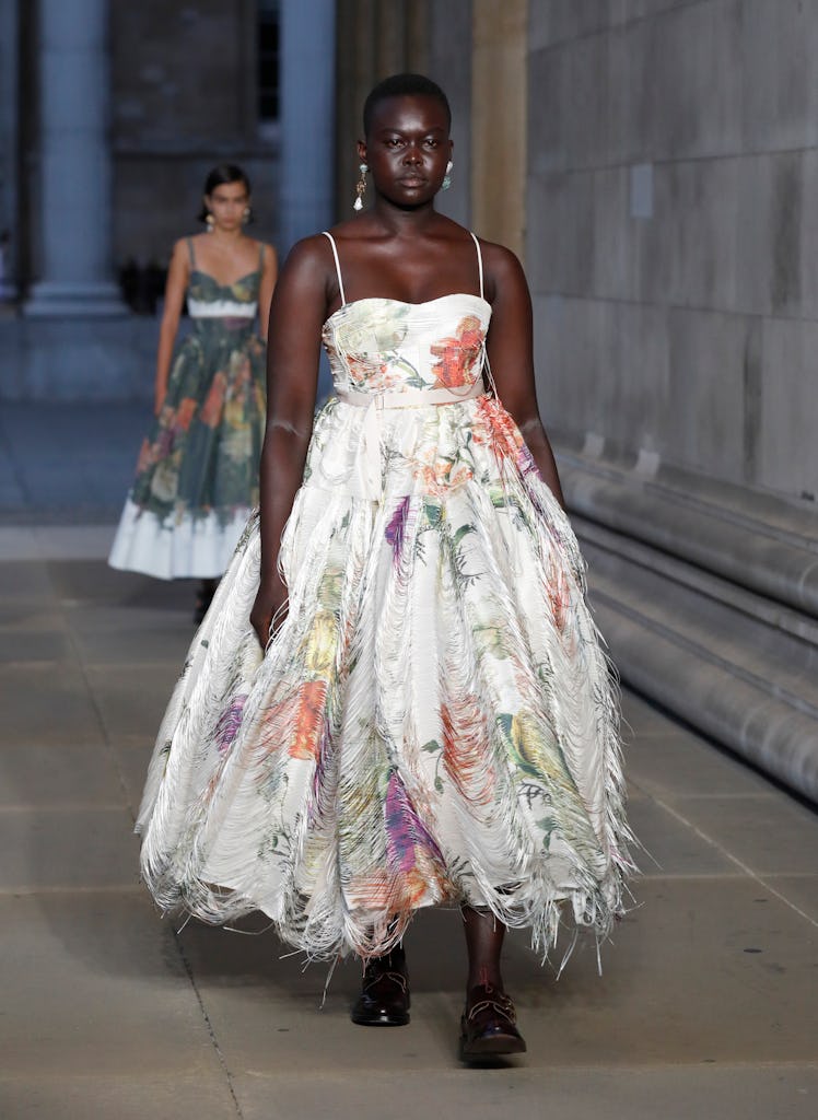 A model walking the runway in a white floral dress at the Erdem show during London Fashion Week 