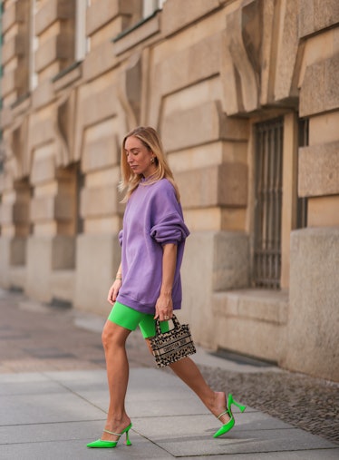 BERLIN, GERMANY - AUGUST 16: Sonia Lyson wears neon green Zara biker shorts, Amina Muaddi green heel...