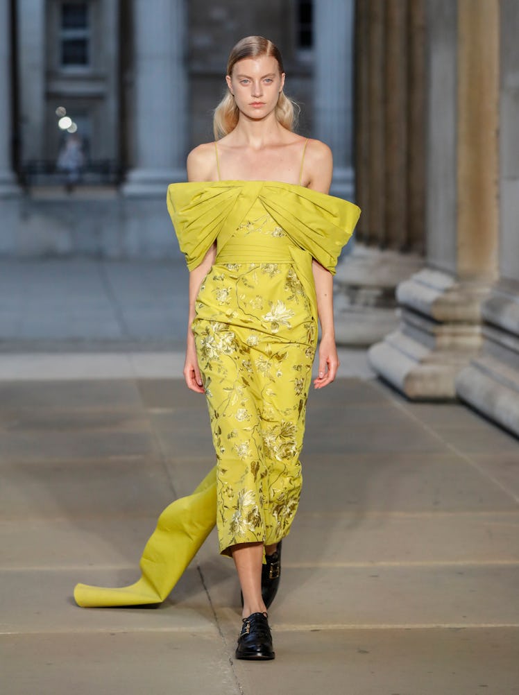 A model walking the runway in a yellow dress at the Erdem show during London Fashion Week 