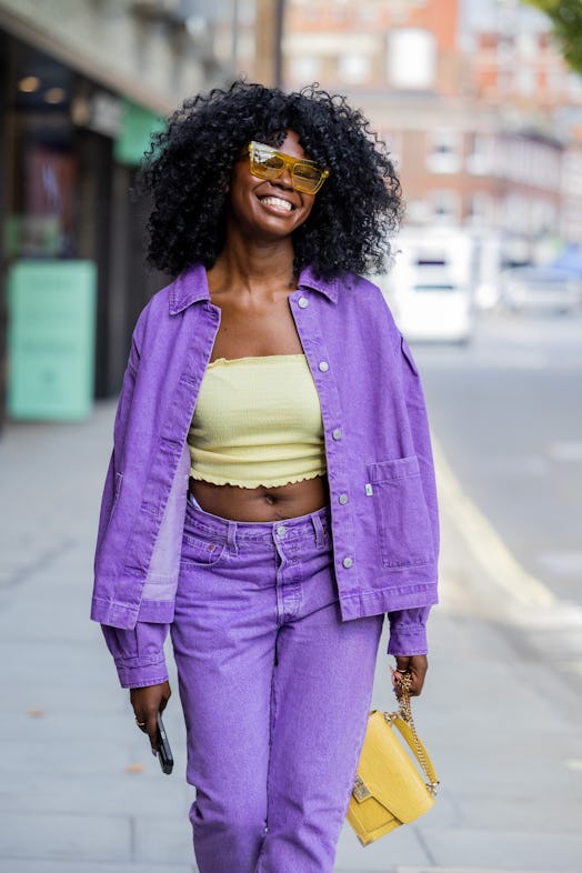 LONDON, ENGLAND - SEPTEMBER 16: A guest wears purple jacket, pants, cropped yellow top outside Bora ...