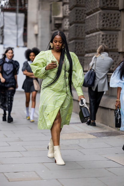 LONDON, UK - SEPTEMBER 18: Guests wear green dresses and black bags outside Simone Rocha during Ron.