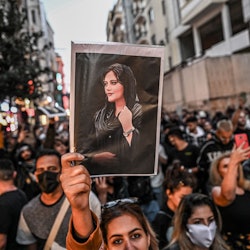 A protester holds a portrait of Mahsa Amini  during a demonstration in support of Amini