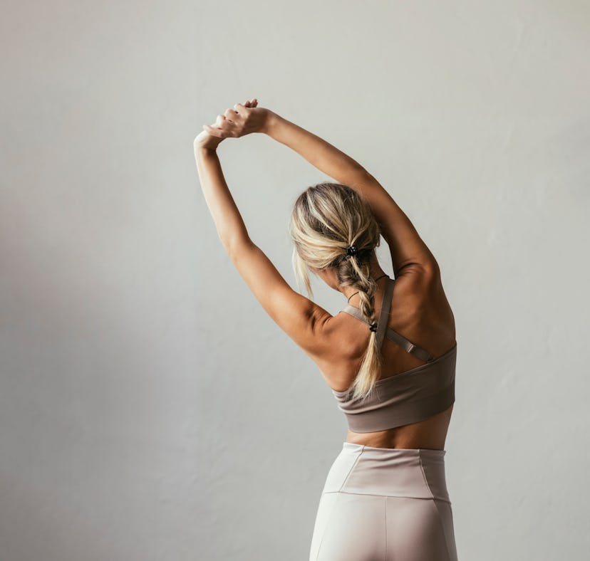 A woman at home is looking up yoga back stretch for any work-from-home back pain.