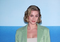 Lili Reinhart posing in a green combination of blazer and pants at the Max Mara Fashion Show