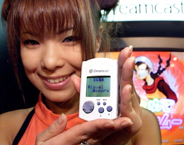 MAKUHARI, JAPAN: Japan's video game giant Sega employee Hiromi Anzai displays the portable video gam...