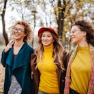 three women enjoy a walk in the park as they discuss the lucky signs that will have the best October...