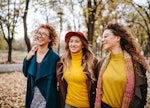 three women enjoy a walk in the park as they discuss the lucky signs that will have the best October...