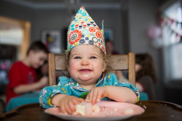 Smiling girl wearing a crown eating her birthday cake in a round up of Bridgerton baby names