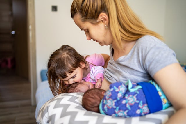 Young mother breastfeeding her newborn babies