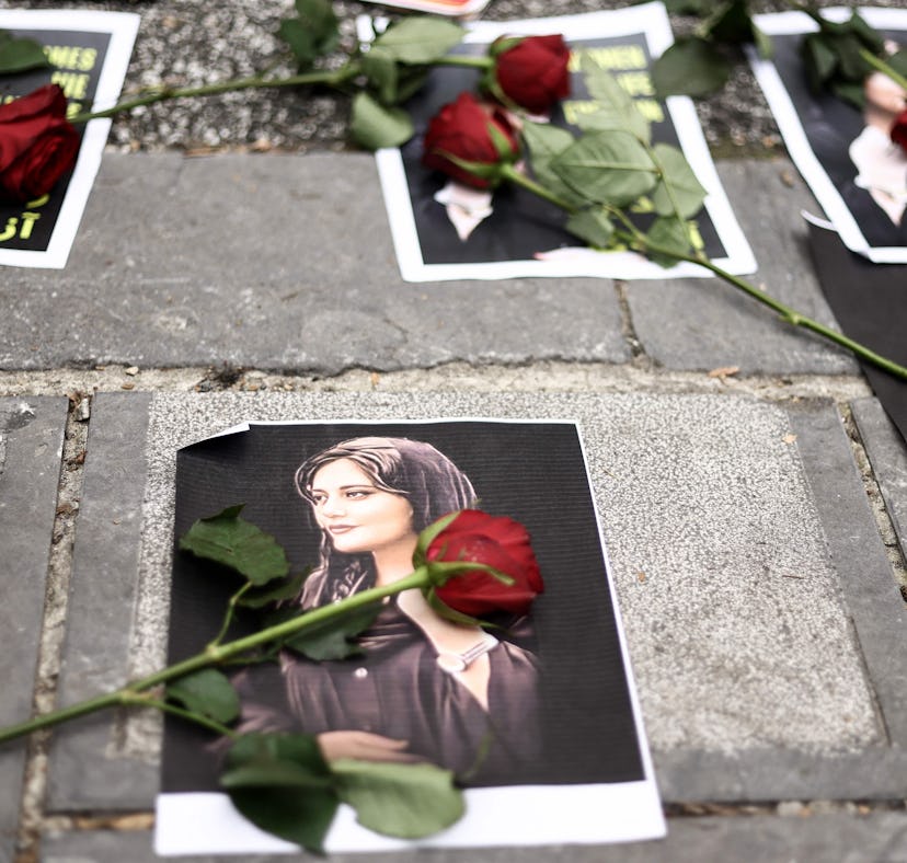 Flowers are seen on a portrait of Mahsa Amini during a demonstration in her support in front of the ...